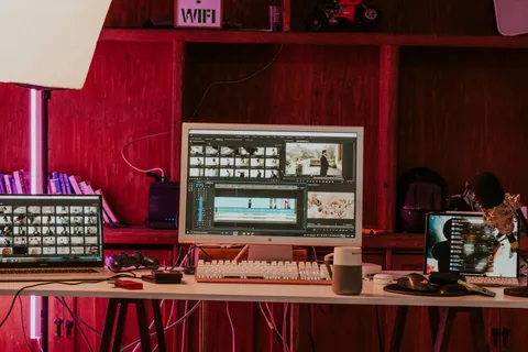 Un poste de montage vidéo avec deux écrans et une timeline de film.